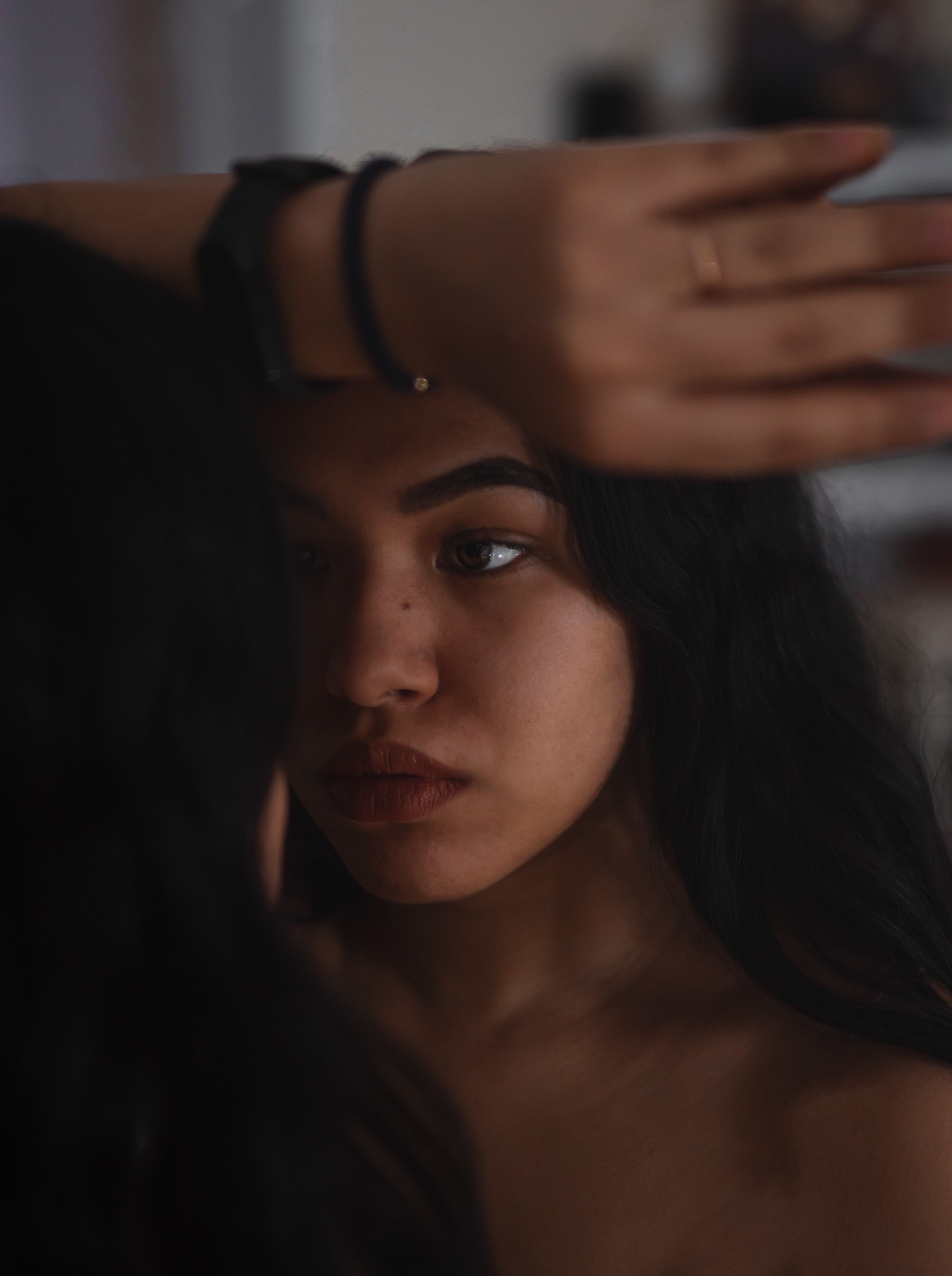 junge Frau schaut voller Selbstzweifel in den Spiegel