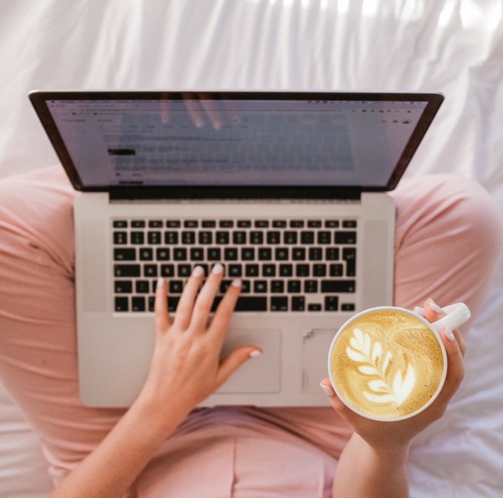 Laptop Macbook auf dem Schoß Kaffee in der Hand - beste Blogs lesen