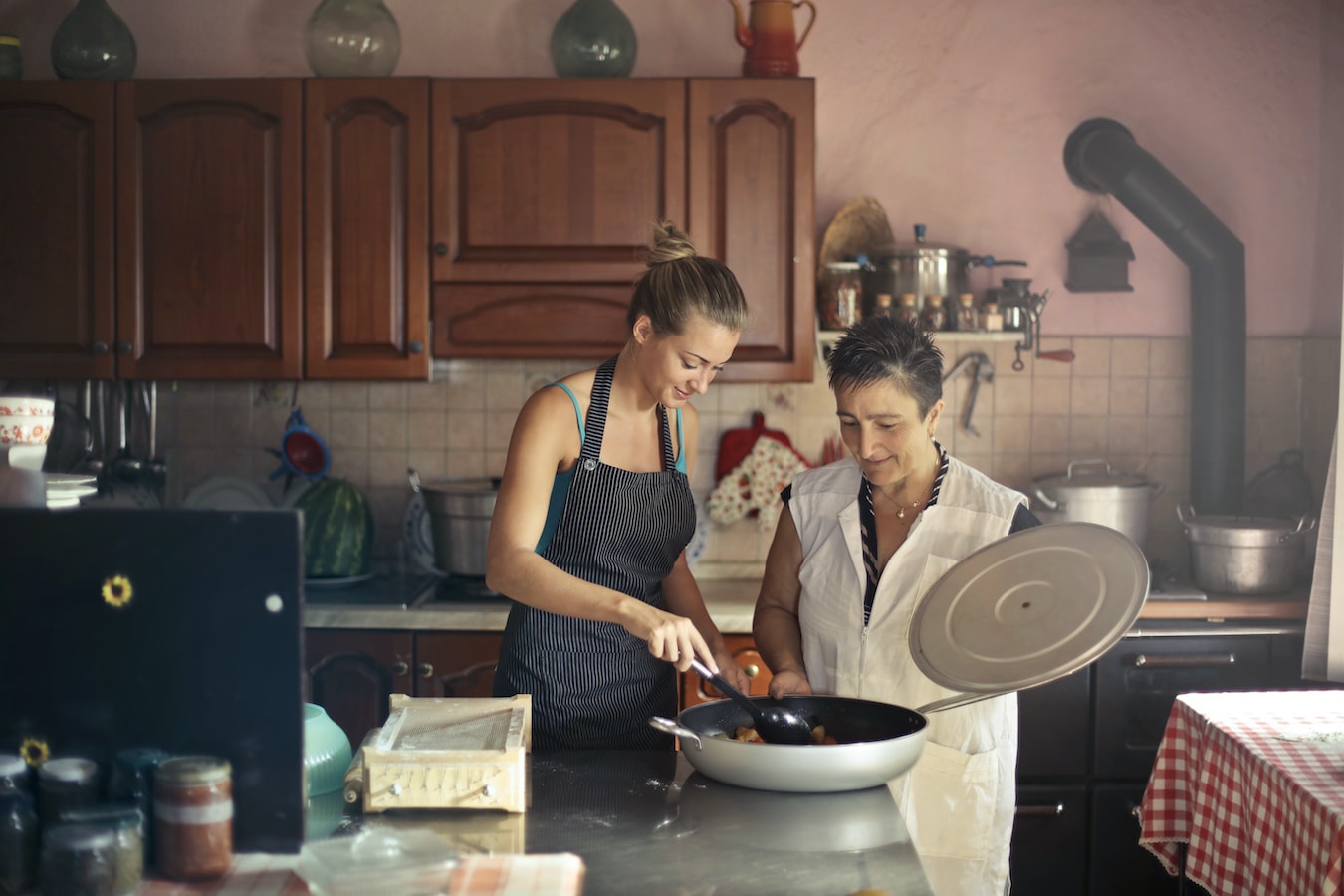 junge Frau und ältere Frau in der Küche kochen zusammen mit Bergamotteöl