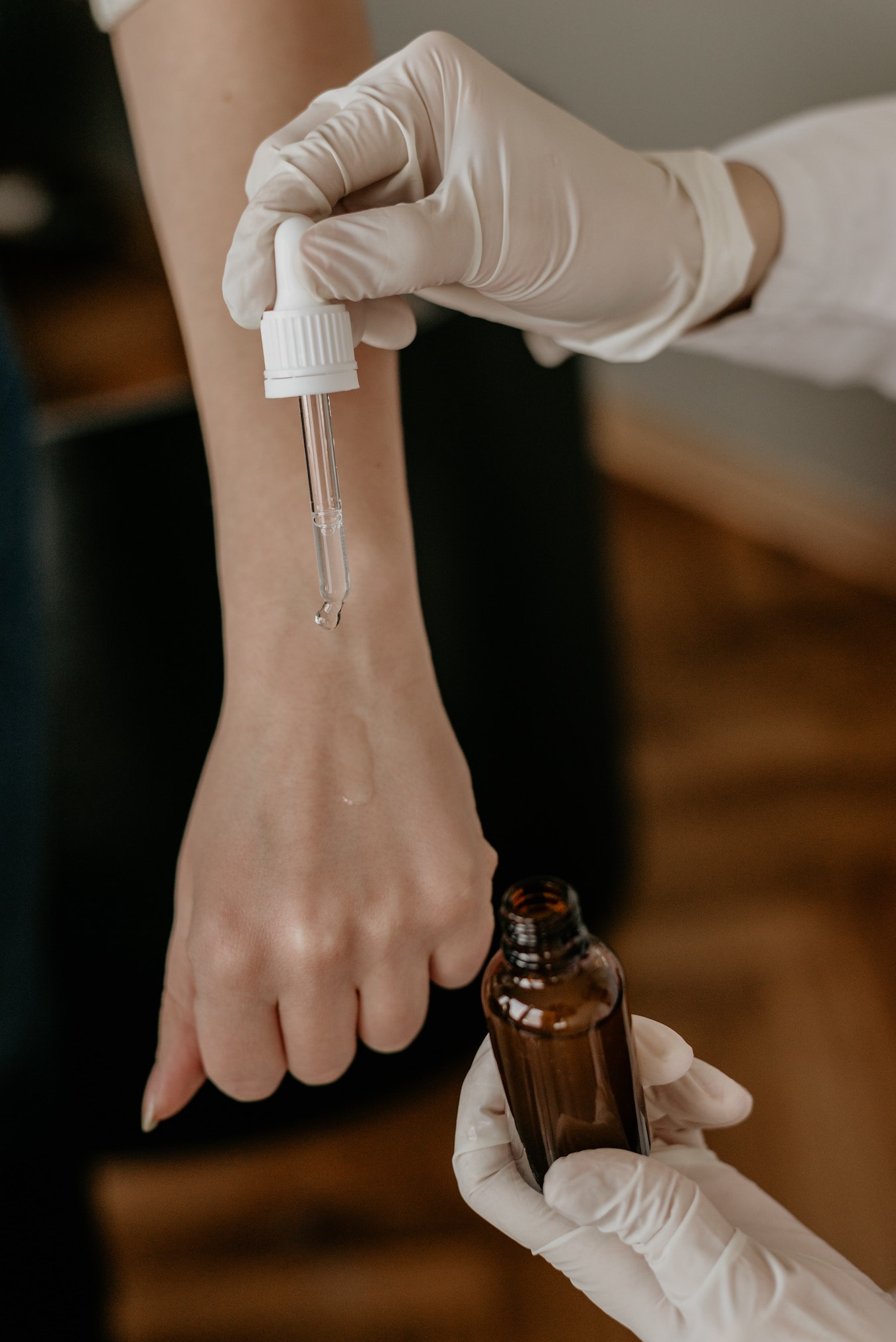 ätherisches Nelkenöl wird mit einer Pipette auf einen Arm getropft Hautpflege mit Öl