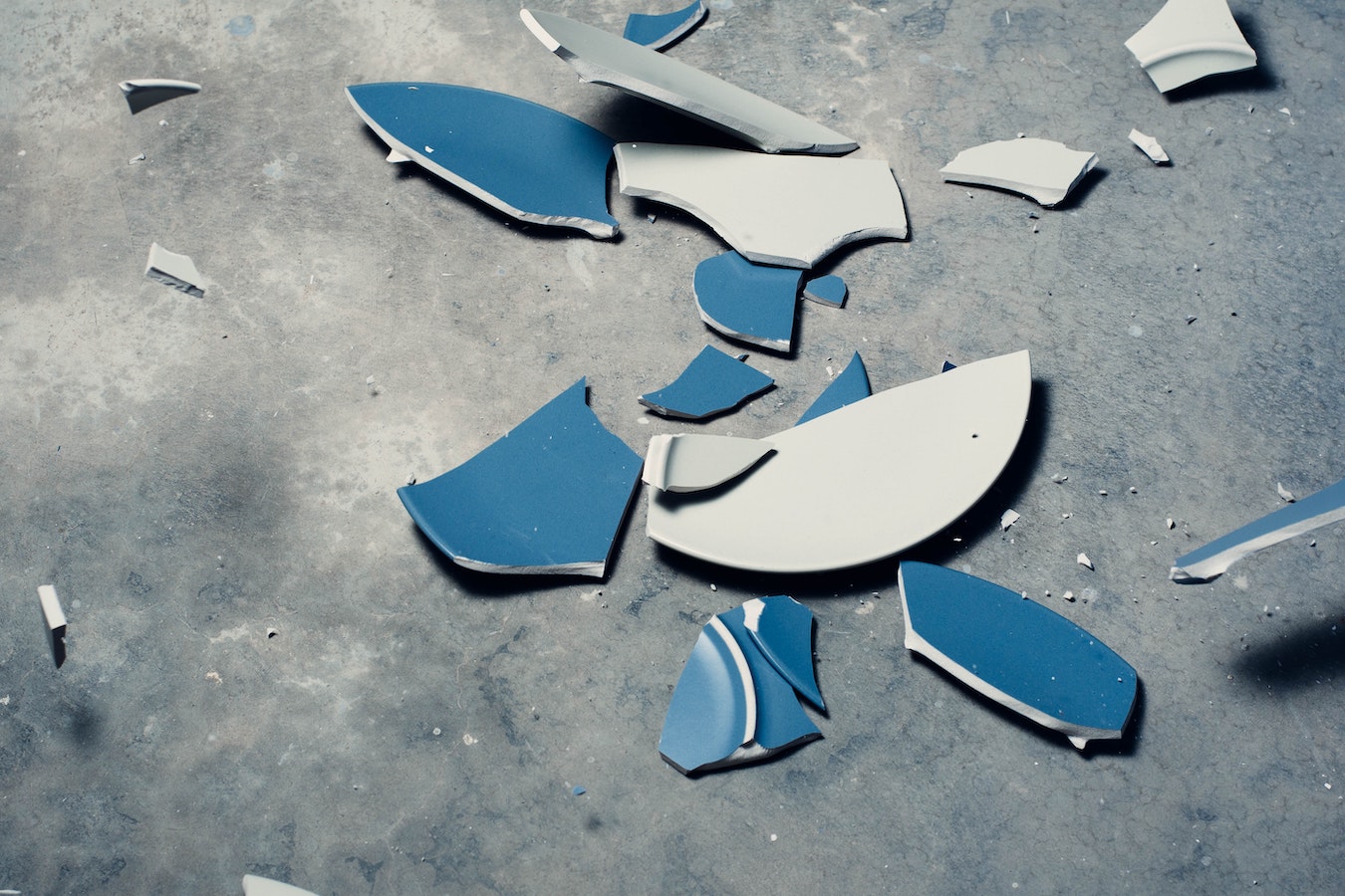 kaputter zerbrochener blauer Teller auf dem Boden - Selbstsabotage Sabotage Niederlage Fail