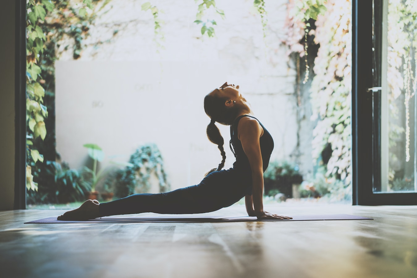 junge Frau macht Yoga auf der Yogamatte um sich abzulenken und den Kopf frei bekommen