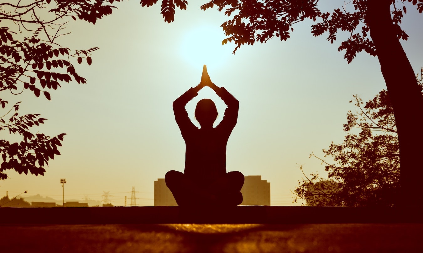 der Schatten einer Person beim Meditieren in der Natur - Meditation unterstützt Selbstheilungskräfte
