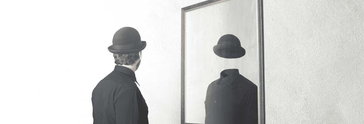 innere Leere - Mann in schwarz mit Hut sieht sich leer im Spiegel