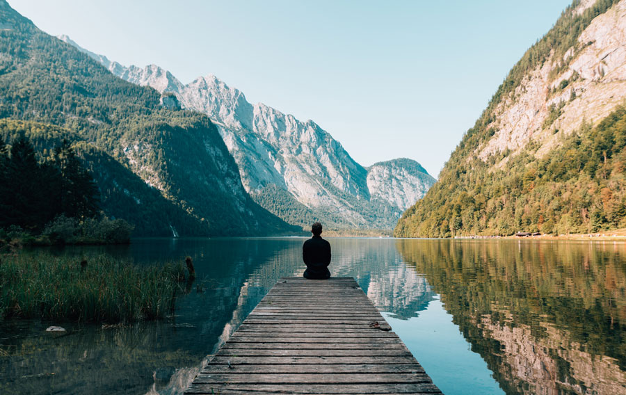 Mann meditiert in den Bergen