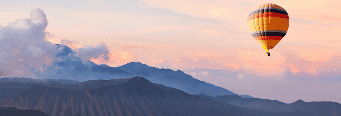 Landschaft mit Bergen und Heißluftballon