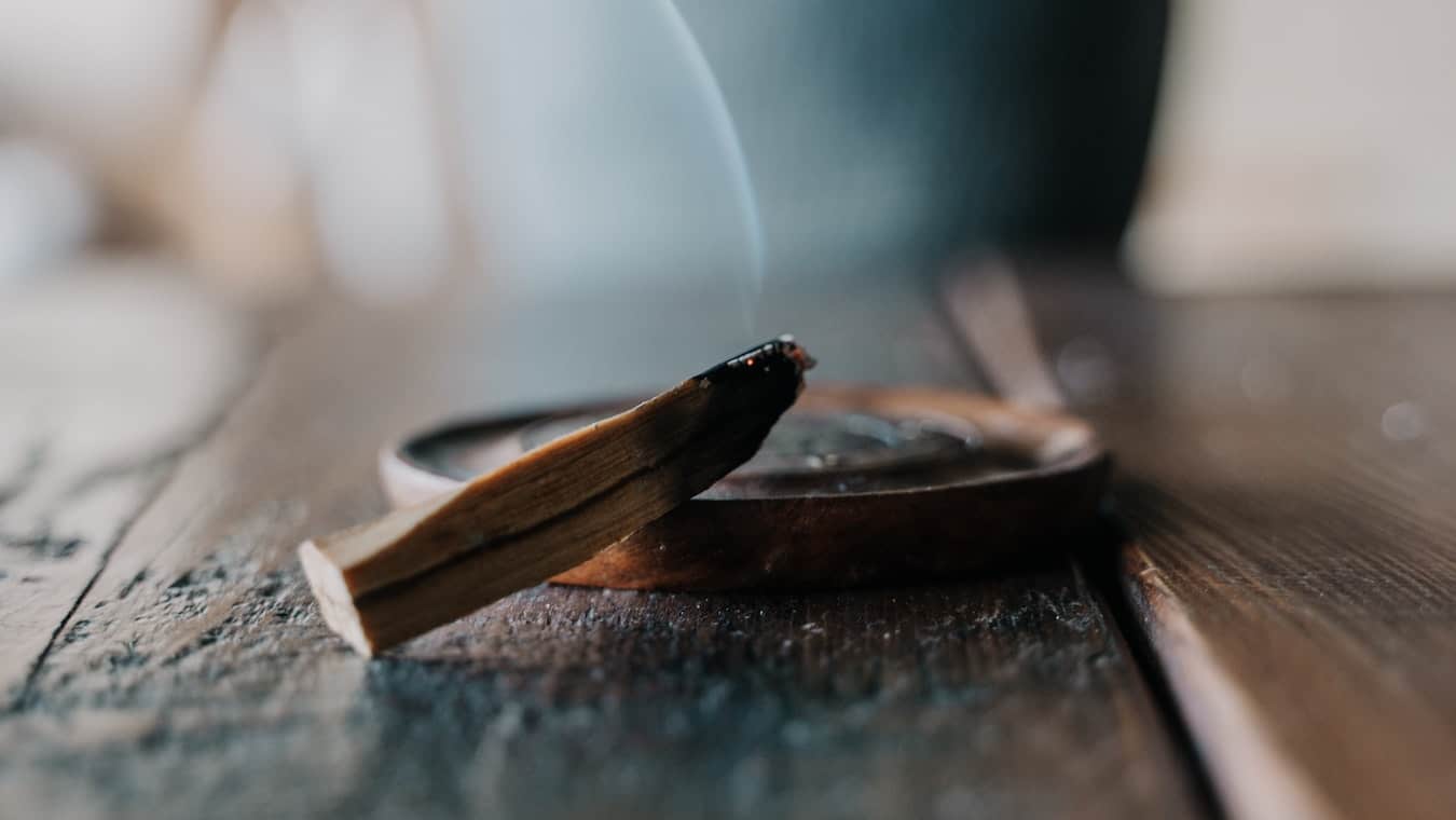 Palo Santo Holz liegt auf braunem Tisch und raucht