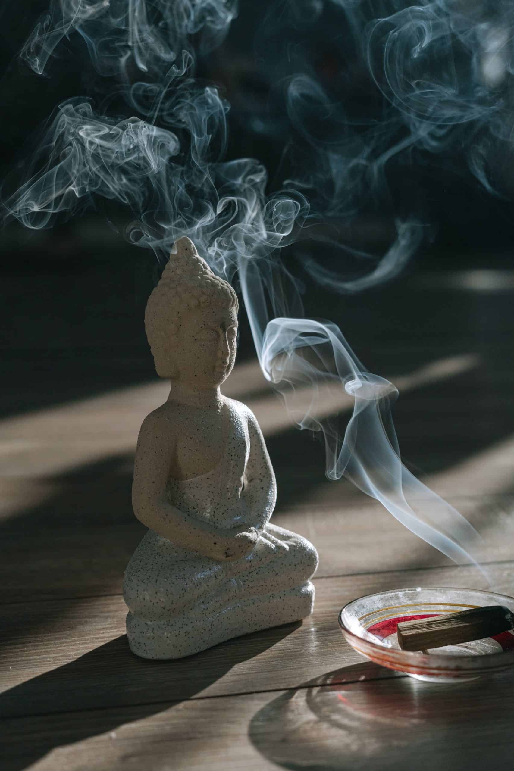 Palo santo räuchert neben einer kleinen Buddha Figur