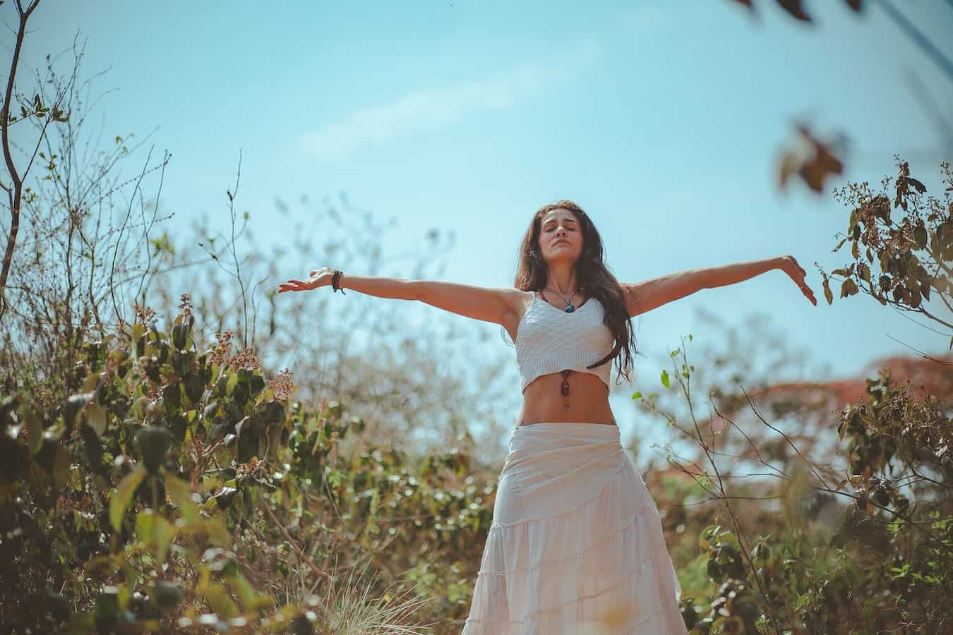 junge Frau im Feld macht die aktive Meditation von Osho