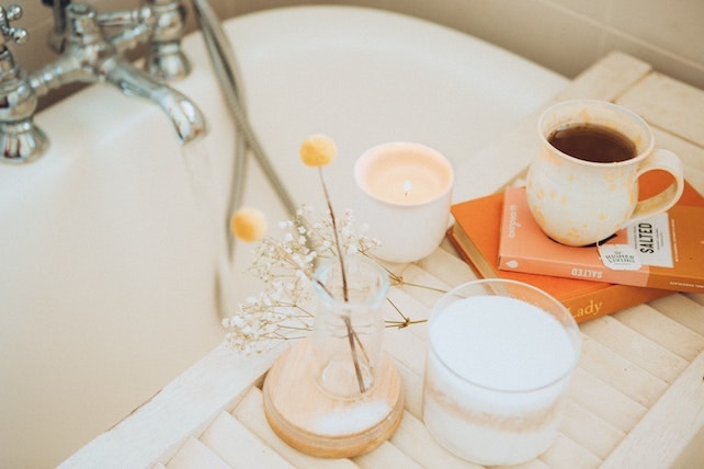 Selbstfürsorge Tee und Blumen neben der Badewanne - Wellnesstag