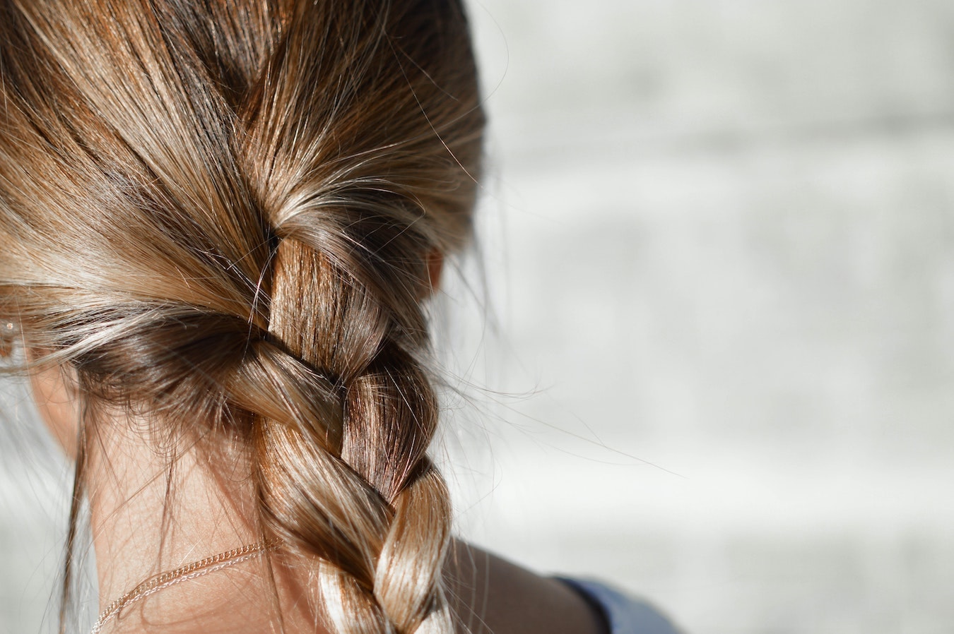 Blonder Zopf junge Frau mit starken dicken Haaren in einen blonden Zopf gebunden