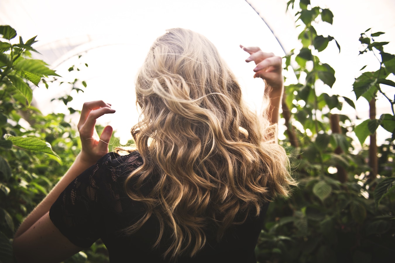 Haare Bergamotteöl junge Frau mit blonden welligen Haaren gepflegte Haare mit Bergamotteöl