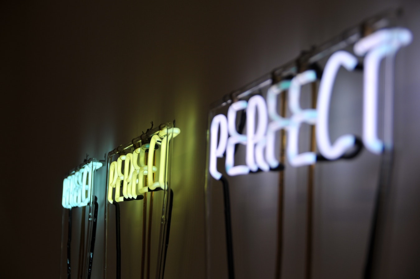 Perfect Perfect, perfekt, perfekt leuchtende Aufschrift an der Wand Perfektionismus