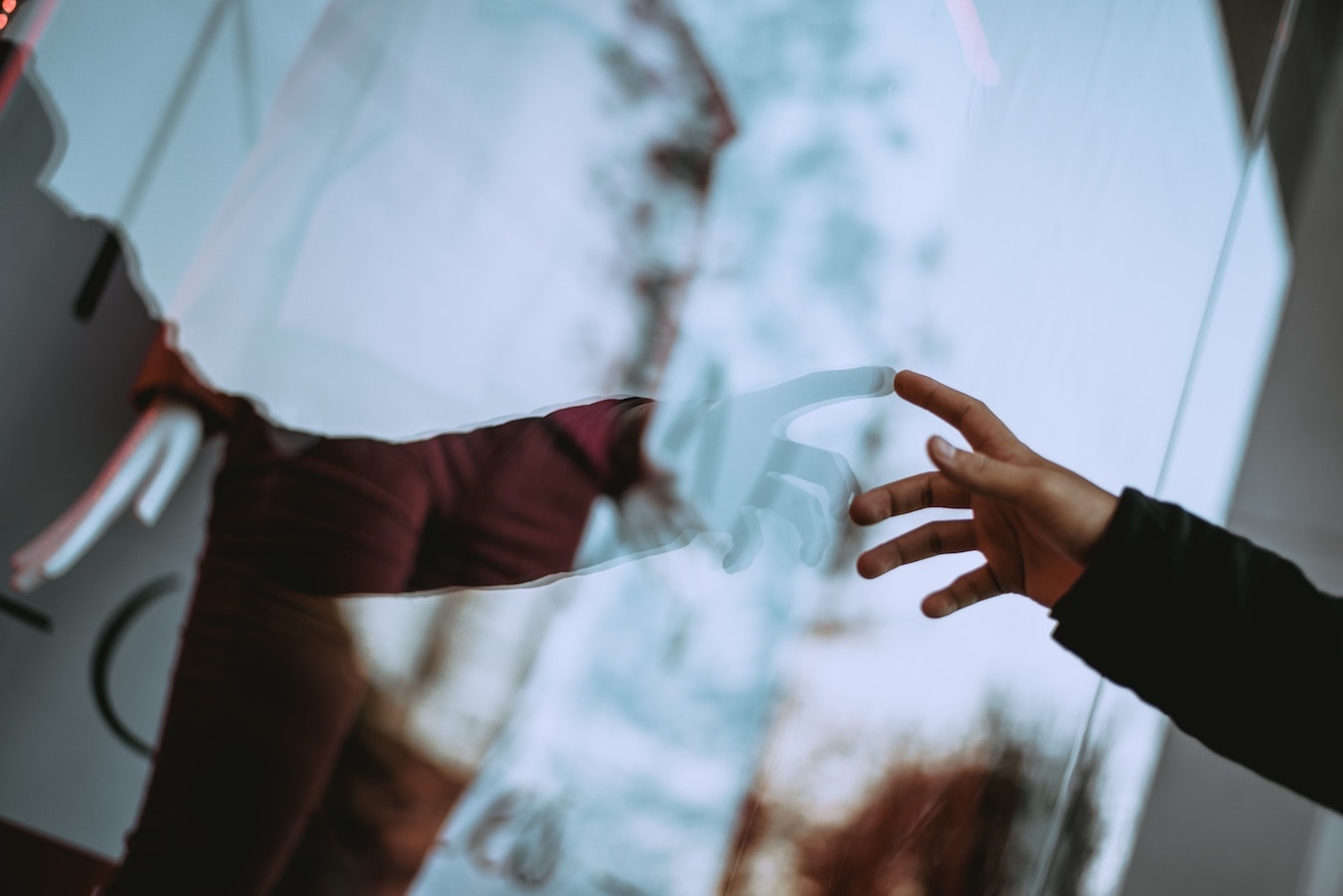 Spiegelbild einer Hand im Fenster: Mit dem höheren Bewusstsein verbinden